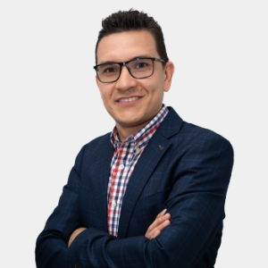 La foto fue tomada en primer plano, fondo blanco y el profesor Carlos Andrés Galán Pinilla está situado en el centro.