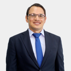 Se presenta al público general y la comunidad educativa al profesor Germán González Silva de la Escuela de Ingeniería de Petróleos. La foto fue tomada en primer plano, fondo blanco y el profesor está situado en el centro.